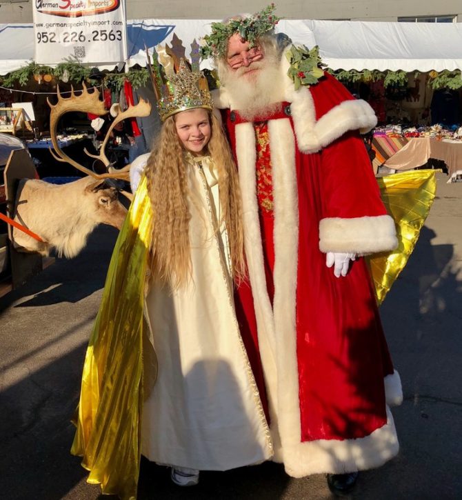 Young girl posing with Santa at the market.