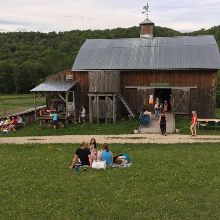 people outside older wooden barn waiting for pizza