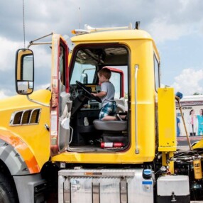 boy in big rig at touch a truck event.