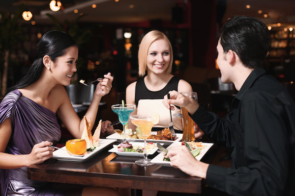 two women and one man at a restaurant.