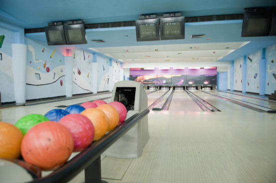 bowling balls in front of brightly lit bowling lane