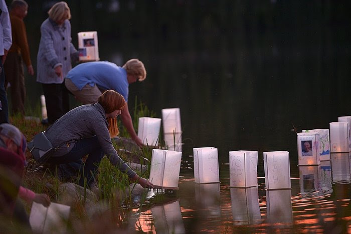 people putting lanterns in the water at Lakewood Cemetery Lantern Lighting Ceremony.