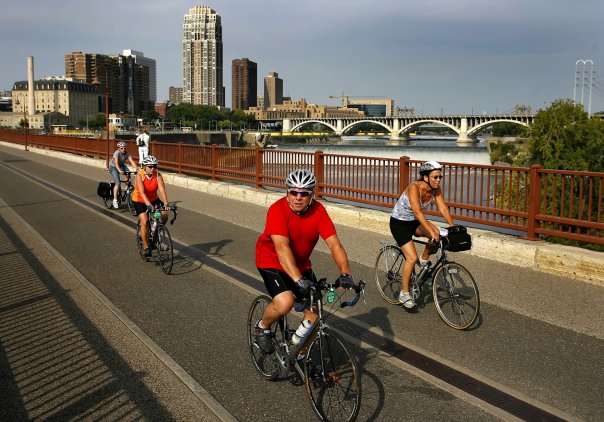 people on bicycles crossing a bridge