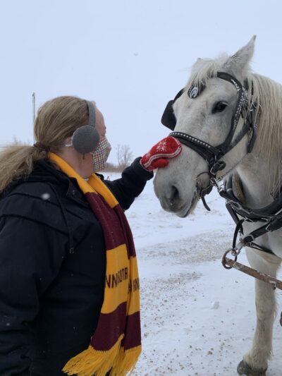 woman petting white horse at Farmamerica Waseca