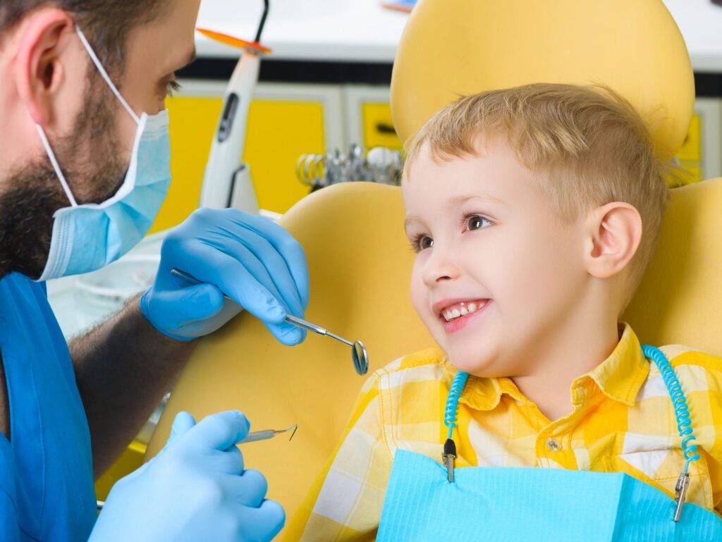 boy in dentist chair listening to dentist