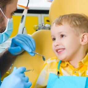 boy in dentist chair listening to dentist.