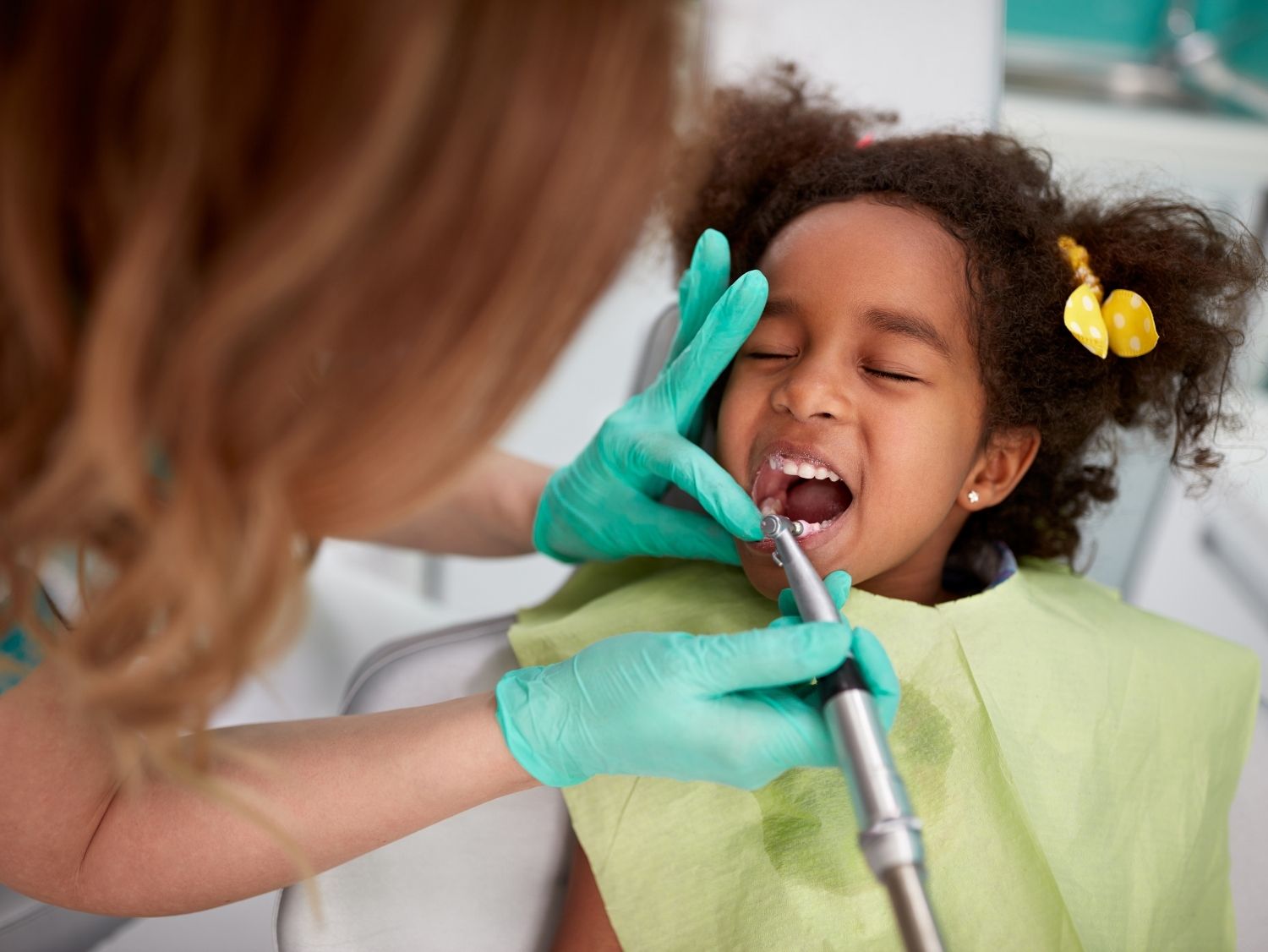 girl at dentist getting a cleaning. 