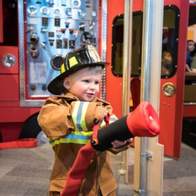Child dressed up as fire fighter at Minnesota Children's Museum.