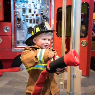 Child dressed up as fire fighter at Minnesota Children's Museum.