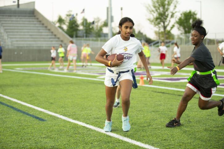 Girl Running with Football at Minnesota Vikings Girls Flag Football Academy