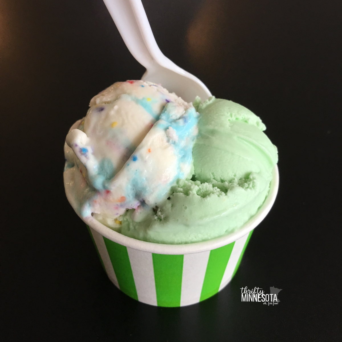 Pistachio and Birthday Cake Ice Cream in Green Striped Cup with plastic spoon