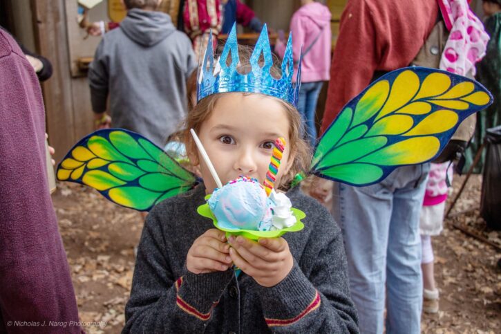 girl with fairy wings and crown eating ice cream