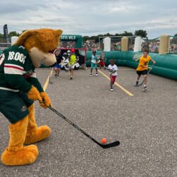 Nordy playing street hockey with kids
