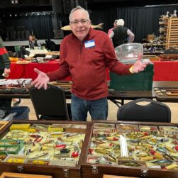 Man in front of vendor table.