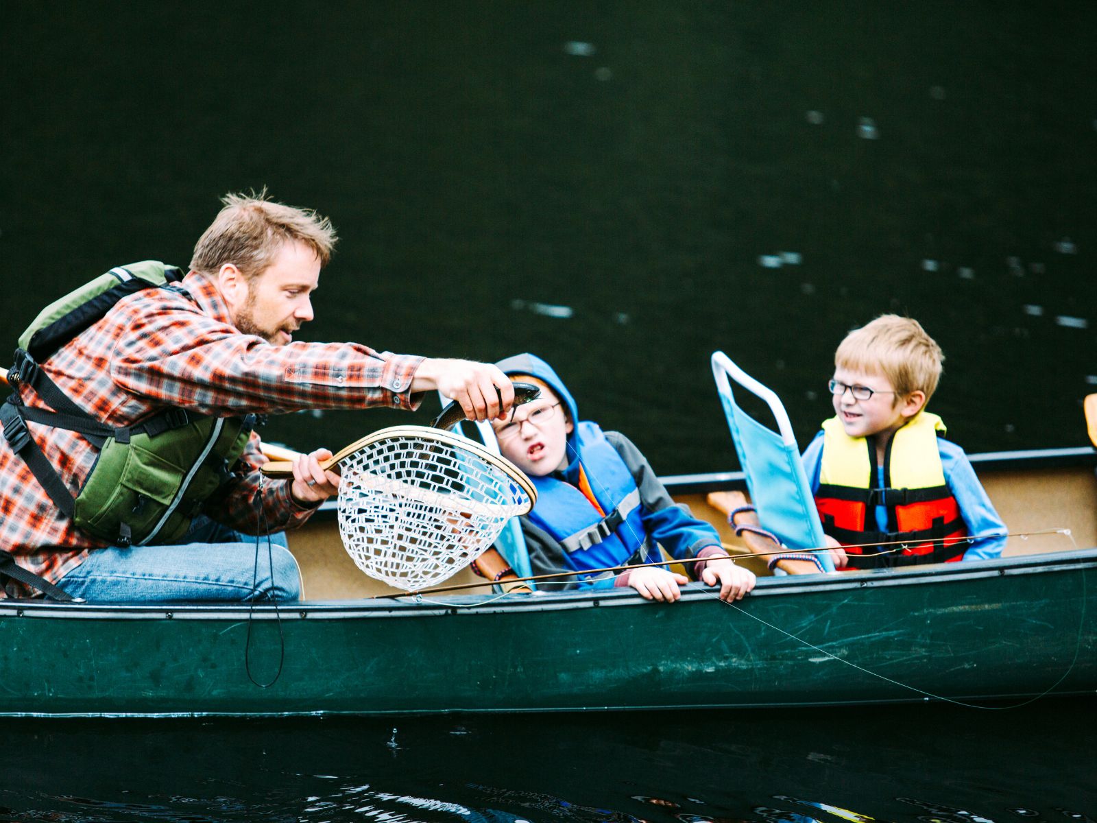 family fishing in canoe.