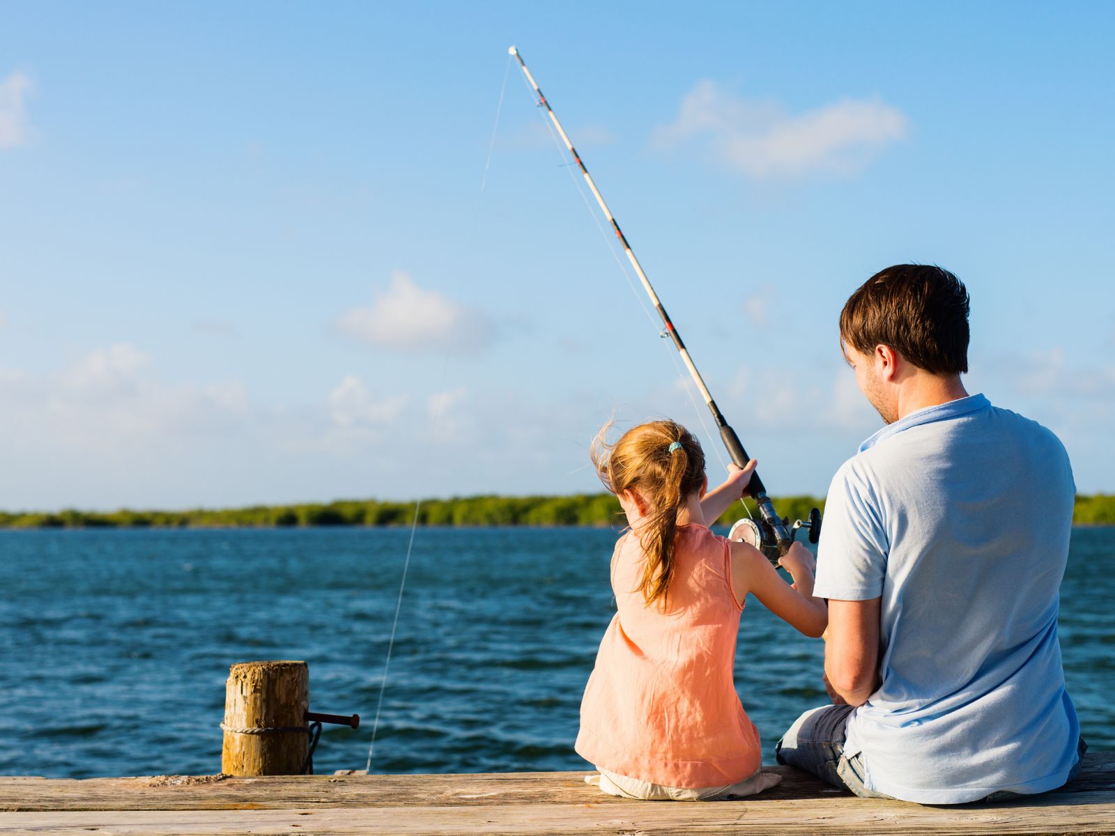 girl and father fishing.