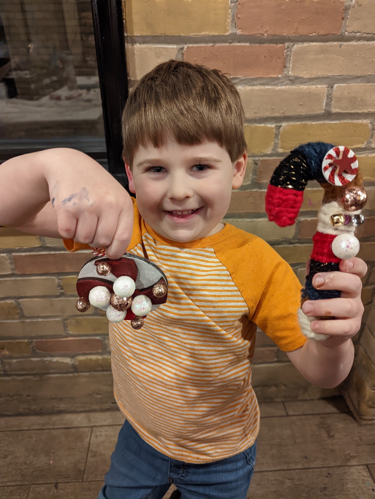 Young boy posing with craft creations at Appleberry's Attic.