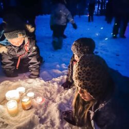 Kids around candles in winter at Belwin Midwinter Fun event.