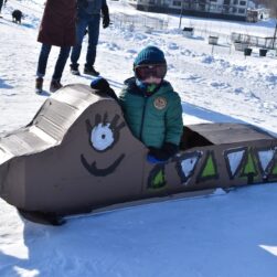 Young child in handmade sled at Frostival.
