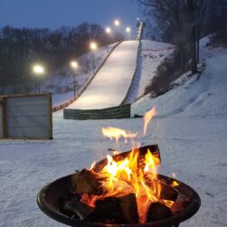 Ski jump ramp with a campfire in front of it.