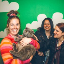 Women cuddling with a cat at Pop Cats Festival.
