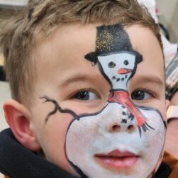 Little boy with snowman face painting.