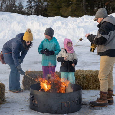 Family enjoying a bonfire at Winter Fest in Cambridge.