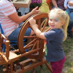 Little girl in front of spindle at Marine Mills Folk School.