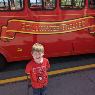 Boy in front of Stillwater Trolley.