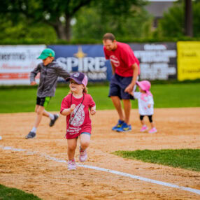 Little child running the bases after baseball game in St. Cloud.