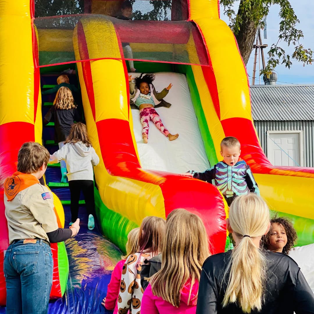 Springtime and Sunshine bounce house with kids inside.