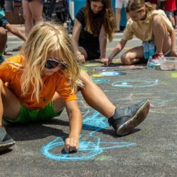 Kid creating a chalk drawing at Chalkfest Maple Grove.