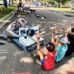 WE Chalk Fest creation with kids taking a picture.