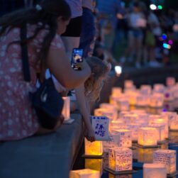 Water Lantern Festival woman holding cell phone near water.