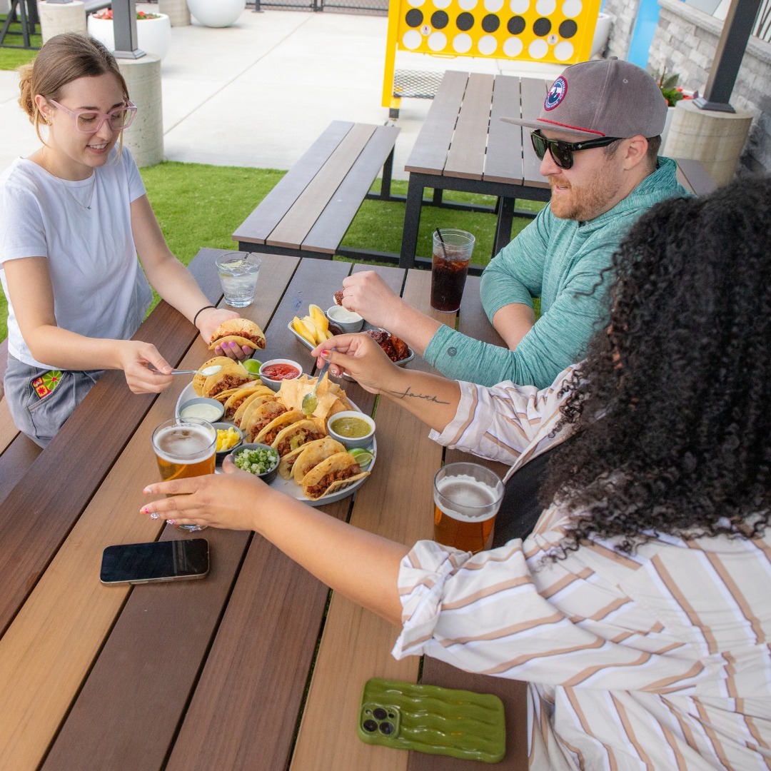 Adults at Smash Park eating outside. 