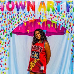 Uptown Art Fair girl posing with an umbrella backdrop.