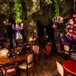 Spooky and mysterious room with cauldrons at each table, books from the walls.