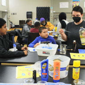 Kids and student teacher in the lab at Metro State University.