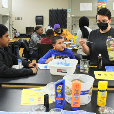Kids and student teacher in the lab at Metro State University.