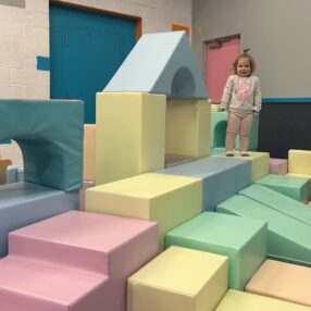 Girl playing on big blocks.