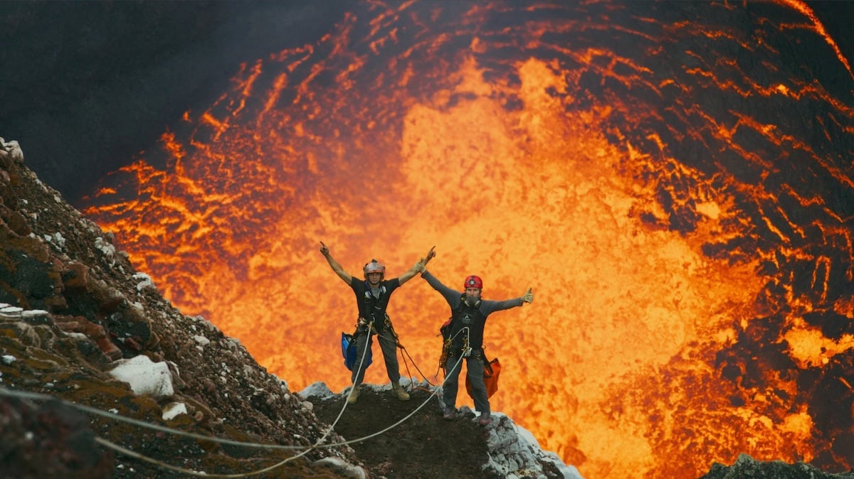Two people repelling down a volcano.