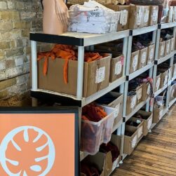 Boxes of clothing on shelves at A Minnesota Brand Warehouse Sale - Hosted by sota clothing.