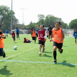 kids playing on field at sanneh foundation summer soccer camp.