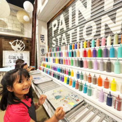 Girl in front of paint station at Hand Mod.