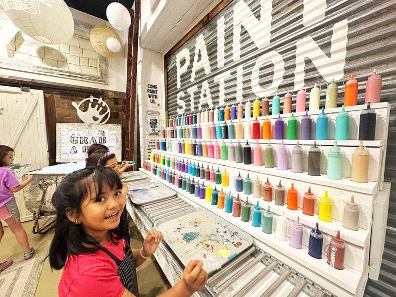 Girl in front of paint station at Hand Mod.