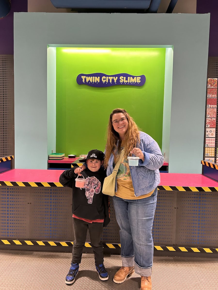 Boy and woman in front of Twin City Slime sign.
