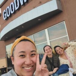 Three women taking a selfie in front of a Goodwill.