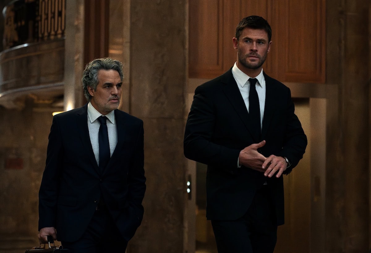 two guys in black suit walking 