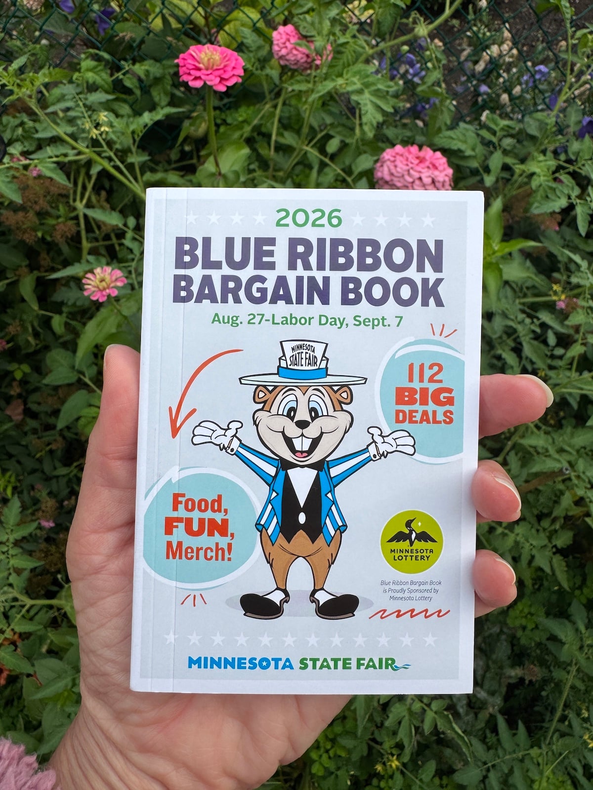 Hand holding 2026 Minnesota State Fair Blue Ribbon Bargain Book.