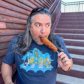 Man eating a Minnesota State Fair corn dog.